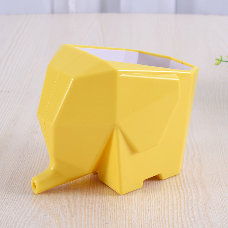Yellow elephant-shaped container on a light wooden surface