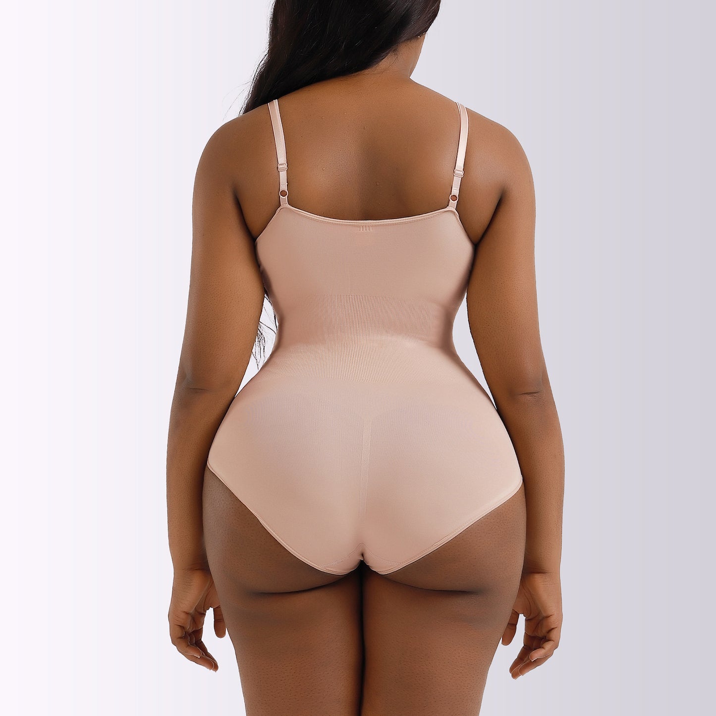 Beige bodysuit worn by a model on a white background