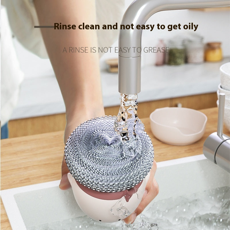 Person rinsing a reusable scrubber under running water in a kitchen sink.