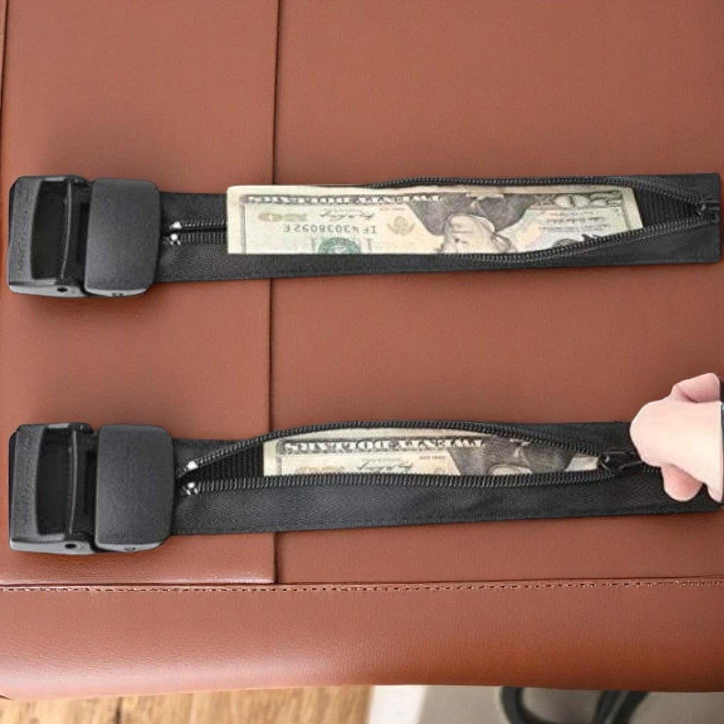 Two black seat belt straps with money on a brown leather seat.