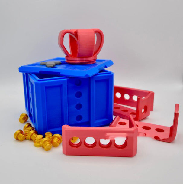Blue and red plastic toy set with a cup on top, surrounded by small yellow objects on a light gray background.
