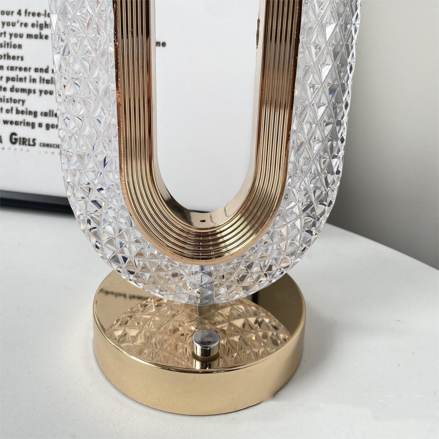 Decorative lamp with crystal shade and gold base on a white surface