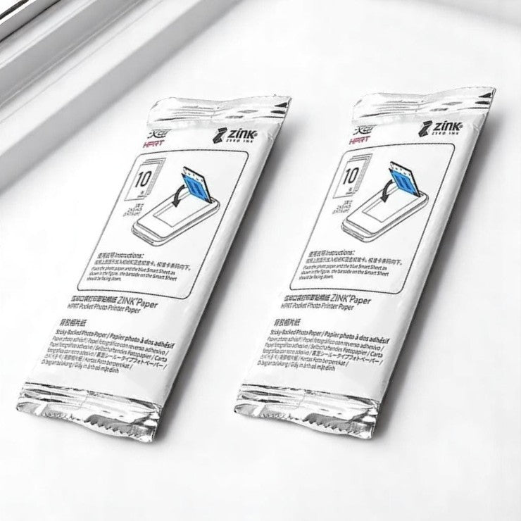 Two packages of Zink photo paper on a white background