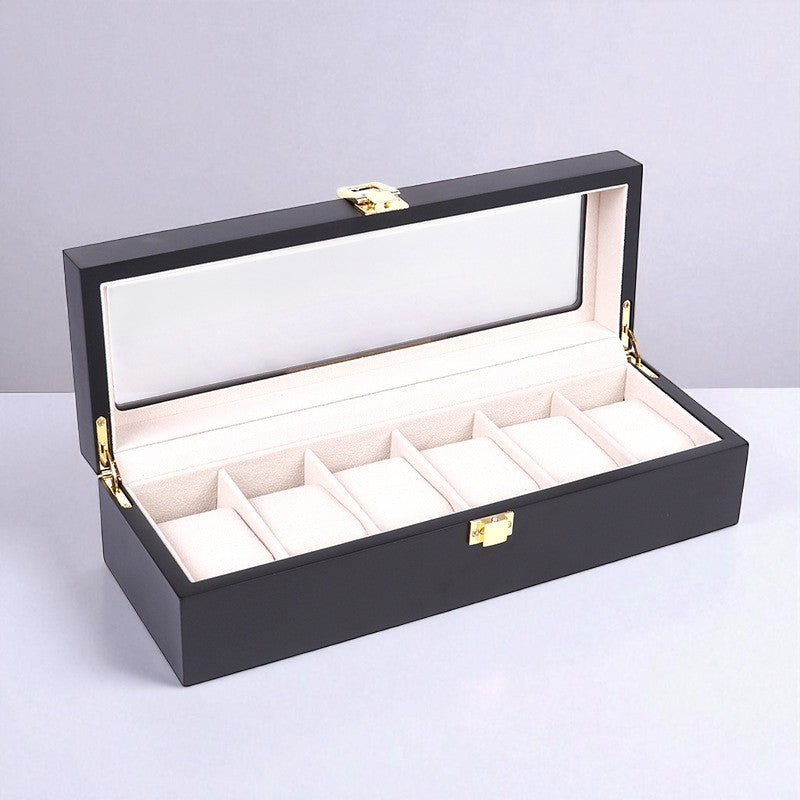 Luxury black watch box with six watches displayed on a light gray background