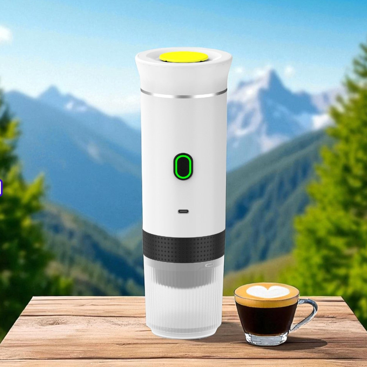 White and black coffee maker with a green button on a wooden table with a scenic mountain background