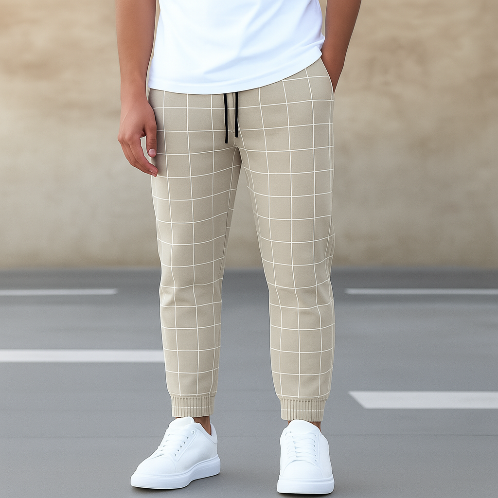 Person wearing beige checkered pants and white sneakers on a blurred street background