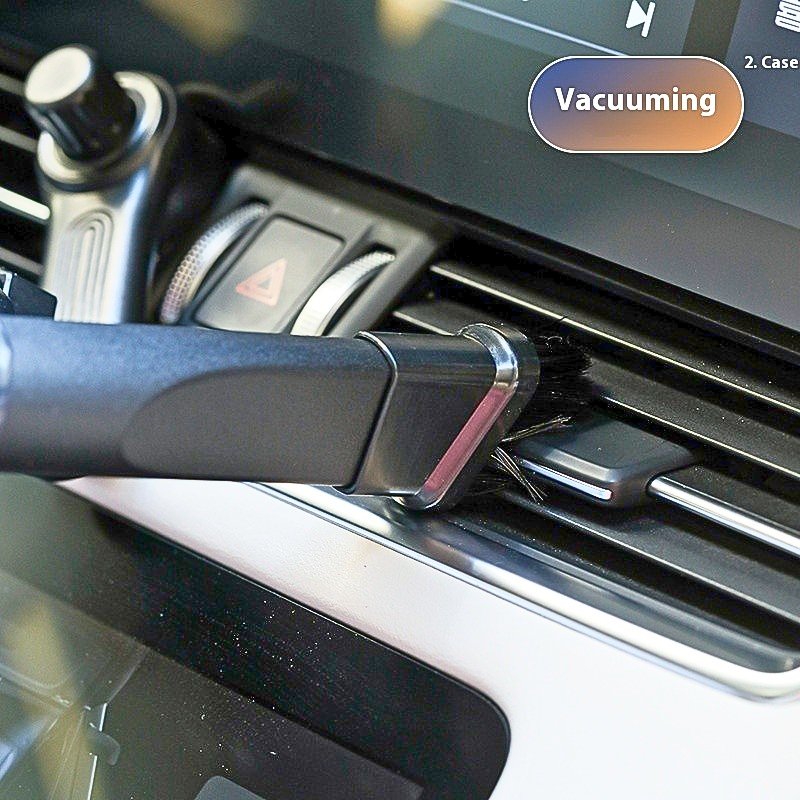 Car air freshener with 'Vacuuming' label attached to a car's air vent.