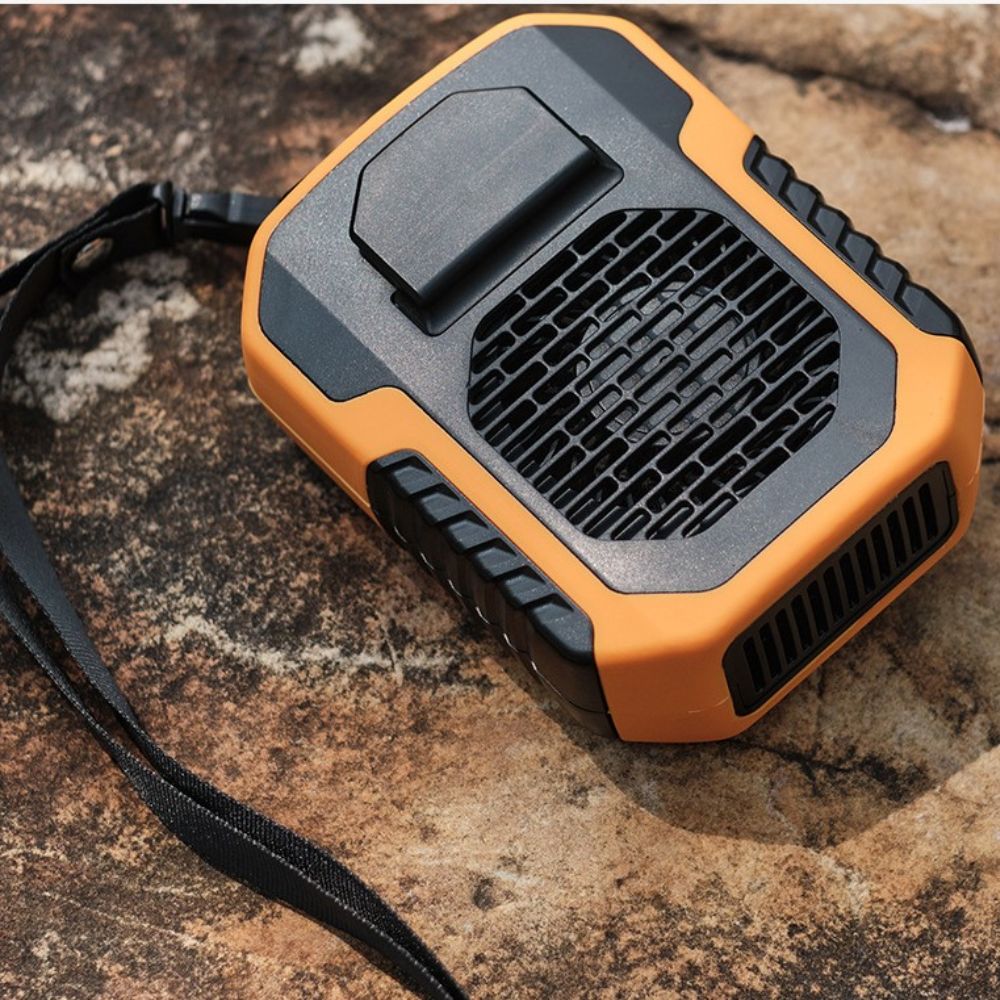 Orange and black portable fan on a textured surface