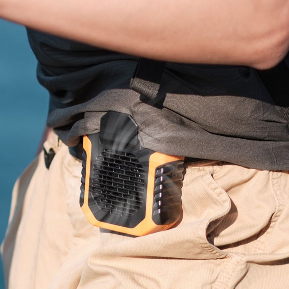 Person wearing a black and orange tool in their pocket with a blurred background