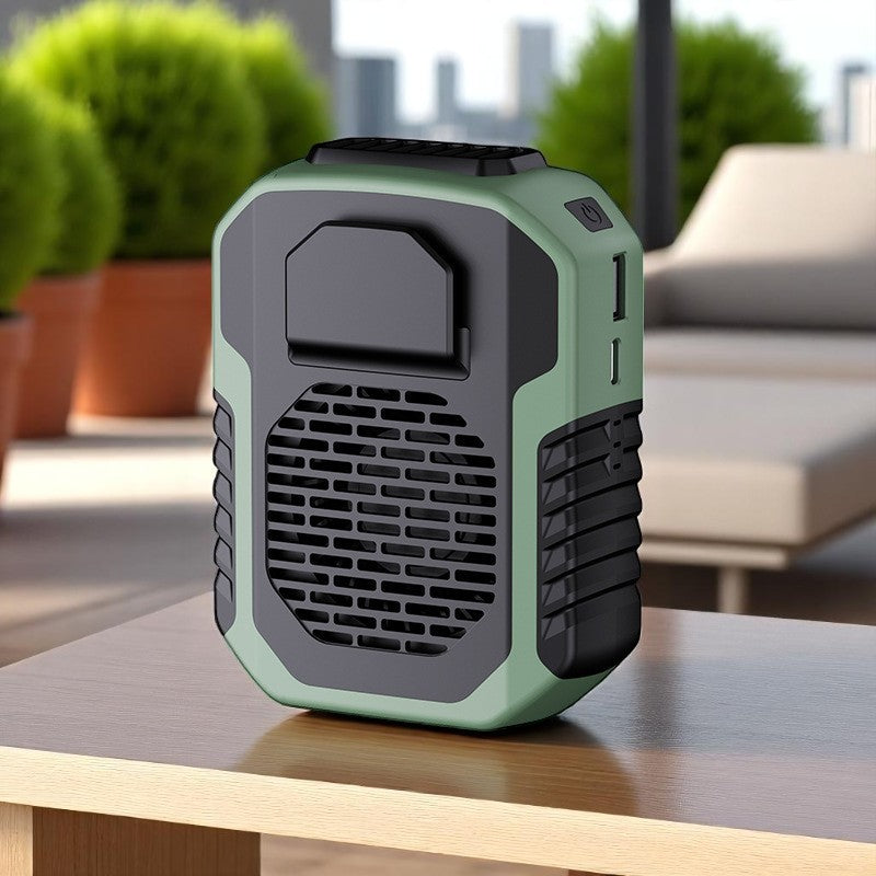 Green and black outdoor fan on a table with plants and furniture in the background