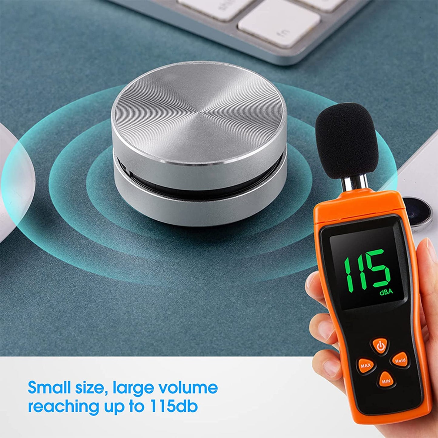 Sound level meter measuring a silver cylindrical device on a desk.