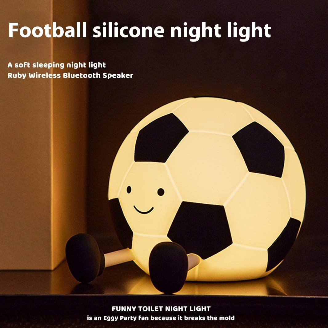 Football-shaped silicone night light with a smiling face on a dark background