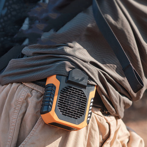 Portable fan attached to a person's belt with a blurred background