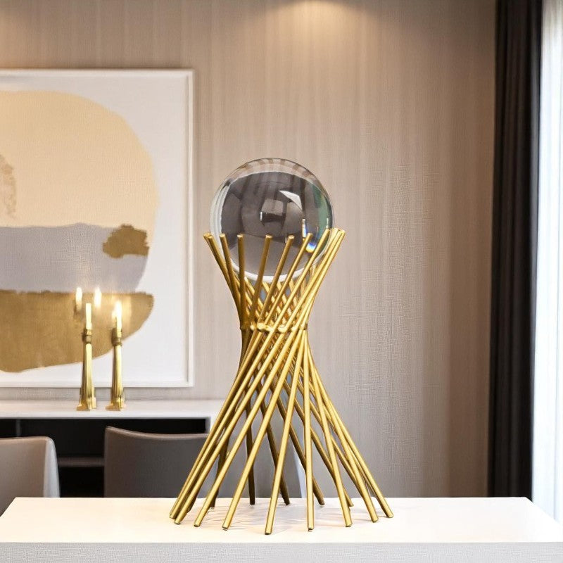 Gold decorative sculpture on a table with a painting in the background