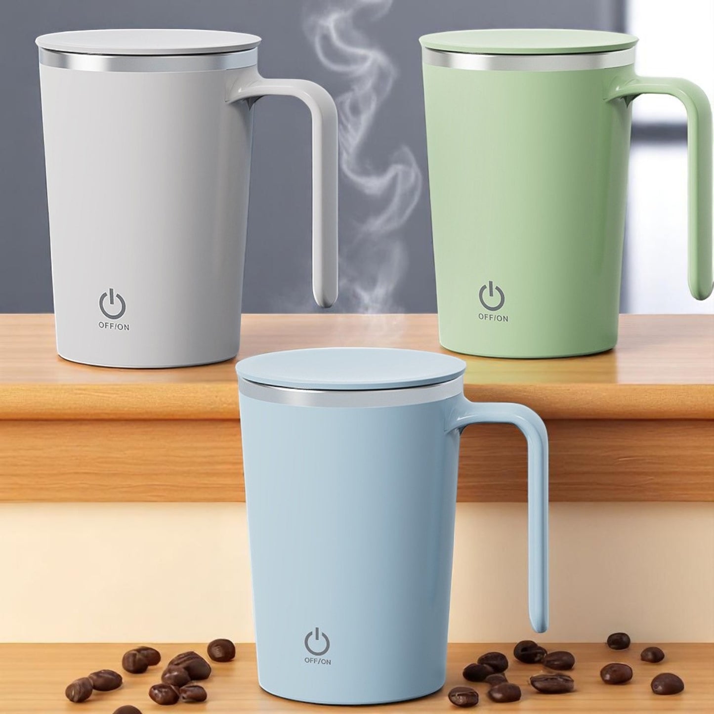 Three insulated mugs in gray, green, and blue on a wooden surface with coffee beans.