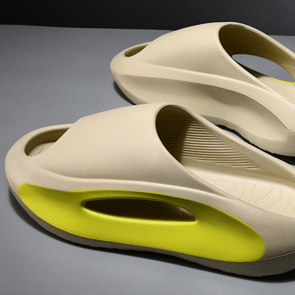 Beige and green sandals on a gray surface