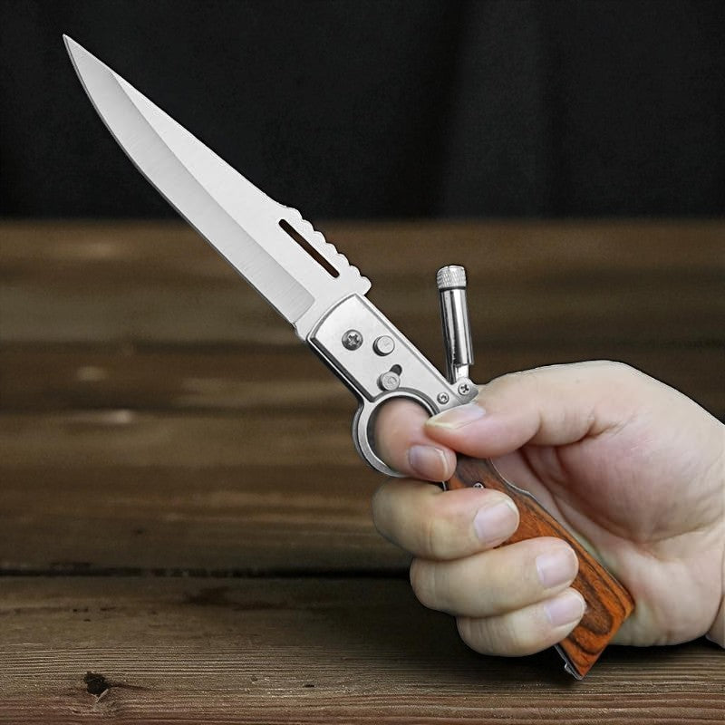 Hand holding a folding knife with a wooden handle on a wooden surface