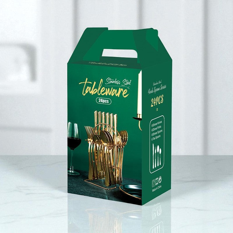 Green box packaging for tableware with gold cutlery and glasses on a white background