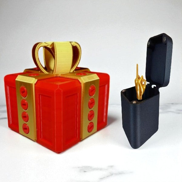 Red and gold gift-shaped box with a black container holding a gold object on a white background
