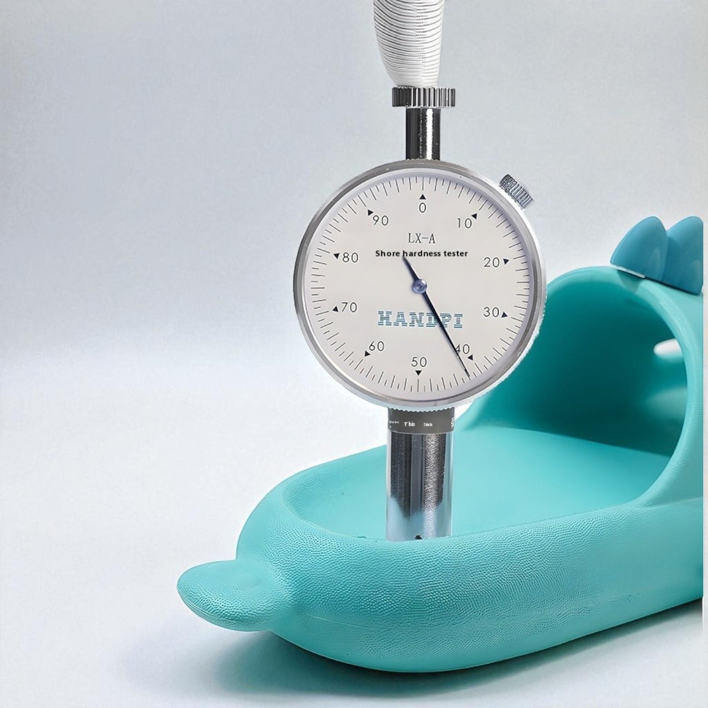 Shoe hardness tester on a light blue background
