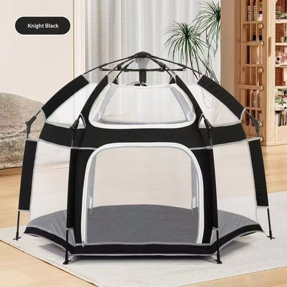 Black and white pet playpen on a light wooden floor with a neutral-colored wall in the background.