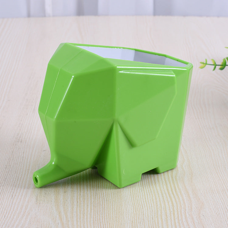 Green elephant-shaped planter on a light wooden surface
