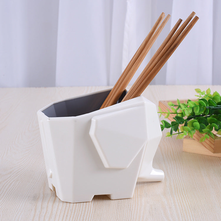 White geometric-shaped holder with chopsticks on a light wooden surface.
