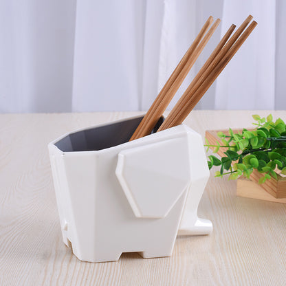 White geometric-shaped holder with chopsticks on a light wooden surface.
