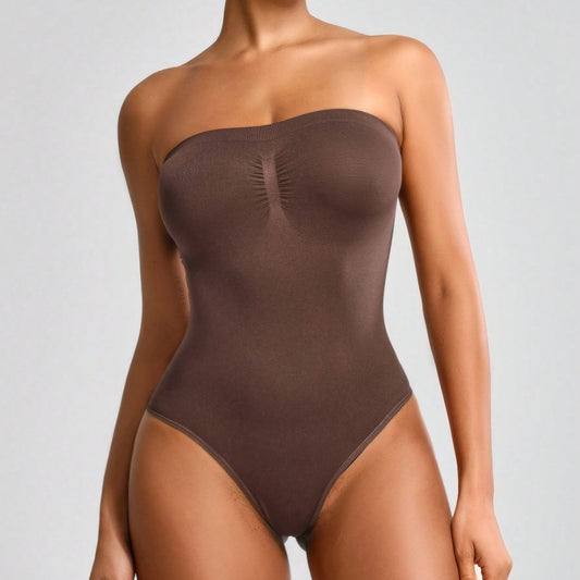 Brown strapless bodysuit worn by a model on a gray background