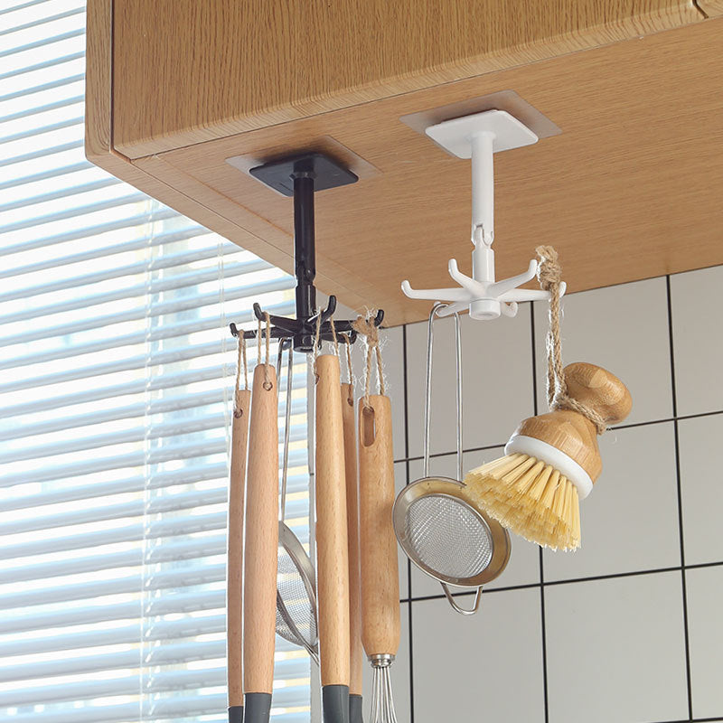 Ceiling hook with kitchen utensils hanging underneath a wooden cabinet.