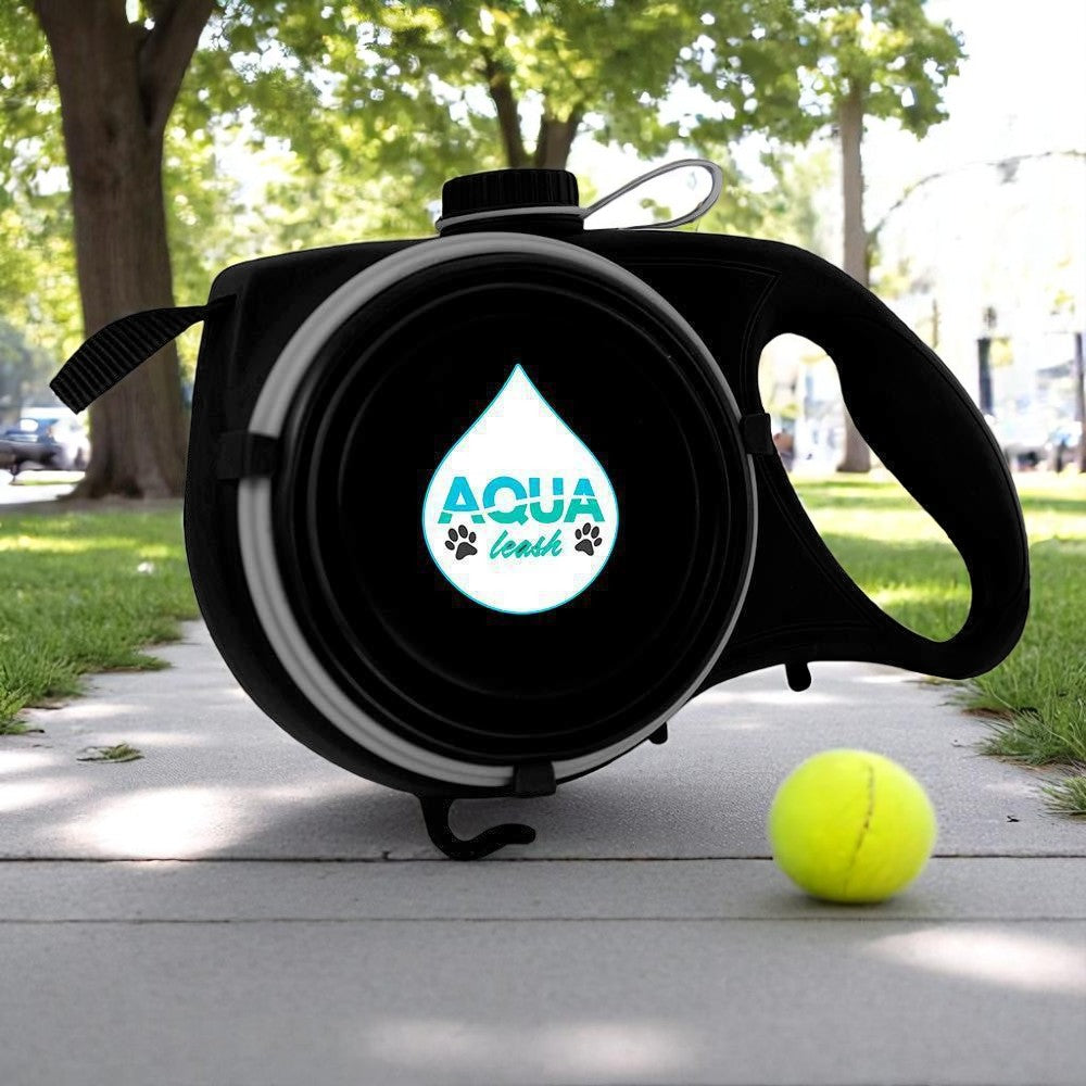 Black pet water bottle with logo on a sidewalk next to a yellow tennis ball.