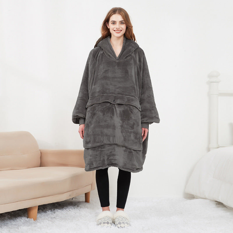 Person wearing a gray fleece poncho in a living room setting