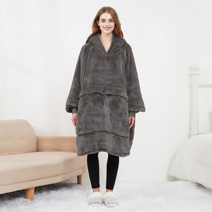 Person wearing a gray fleece poncho in a living room setting