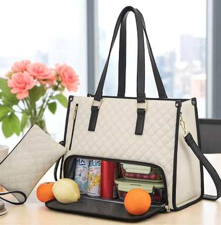 White tote bag with black handles and interior compartments on a desk with office items.
