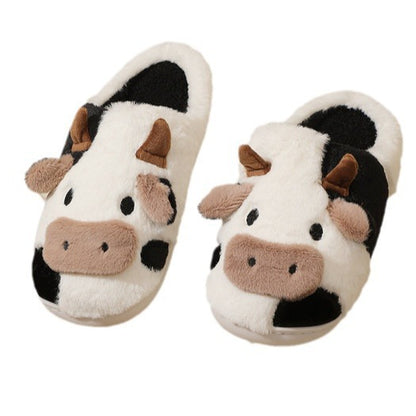 Pair of cow-themed slippers on a white background