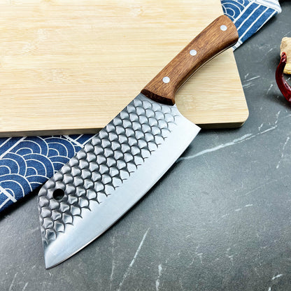 Kamagata knife with textured blade on a wooden cutting board