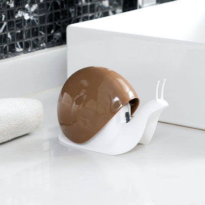 Snail-shaped object on a white surface with a tiled wall in the background