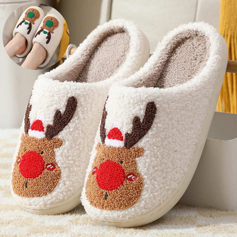 Pair of white slippers with reindeer face design on a soft surface.
