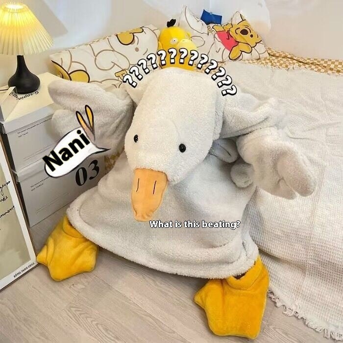 Plush toy resembling a duck with a confused expression on a bed