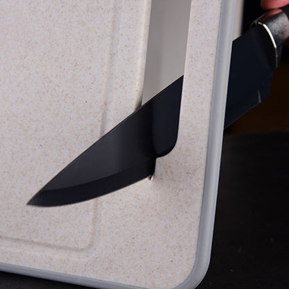 Black knife blade inserted into a white plastic container