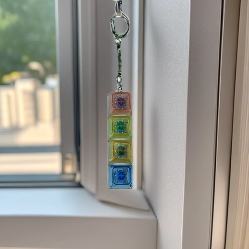 RGB mechanical keyboard switch tester keychain with four colored clicky switches hanging by a window