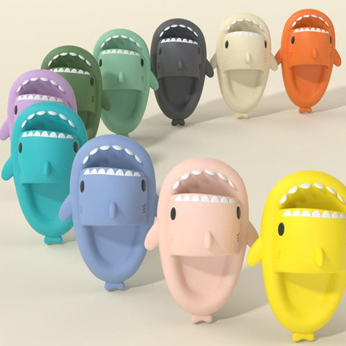 A collection of colorful shark-shaped slippers in various colors including blue, green, gray, orange, pink, and yellow.