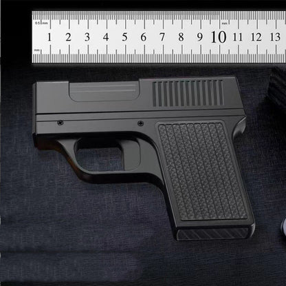 Black gun model on a dark surface with a ruler for scale.