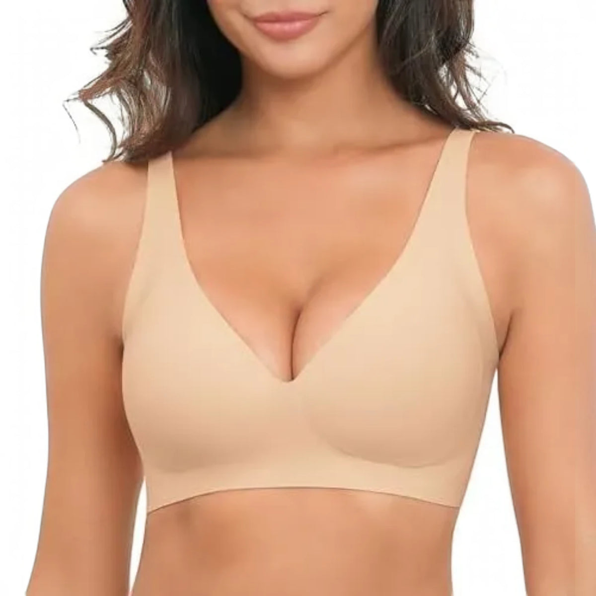 A woman wearing a seamless, unlined bralette in a light beige/nude color, shown from the chest up against a plain white background.