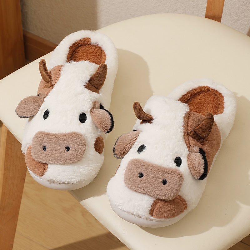 Pair of cow-themed slippers on a chair