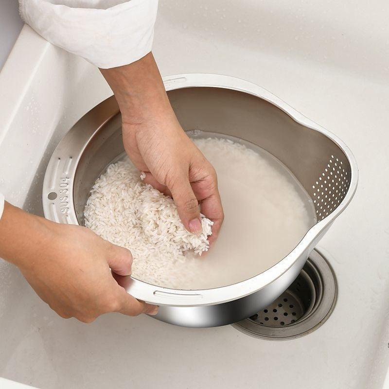 Person rinsing rice in a metal strainer over a sink.