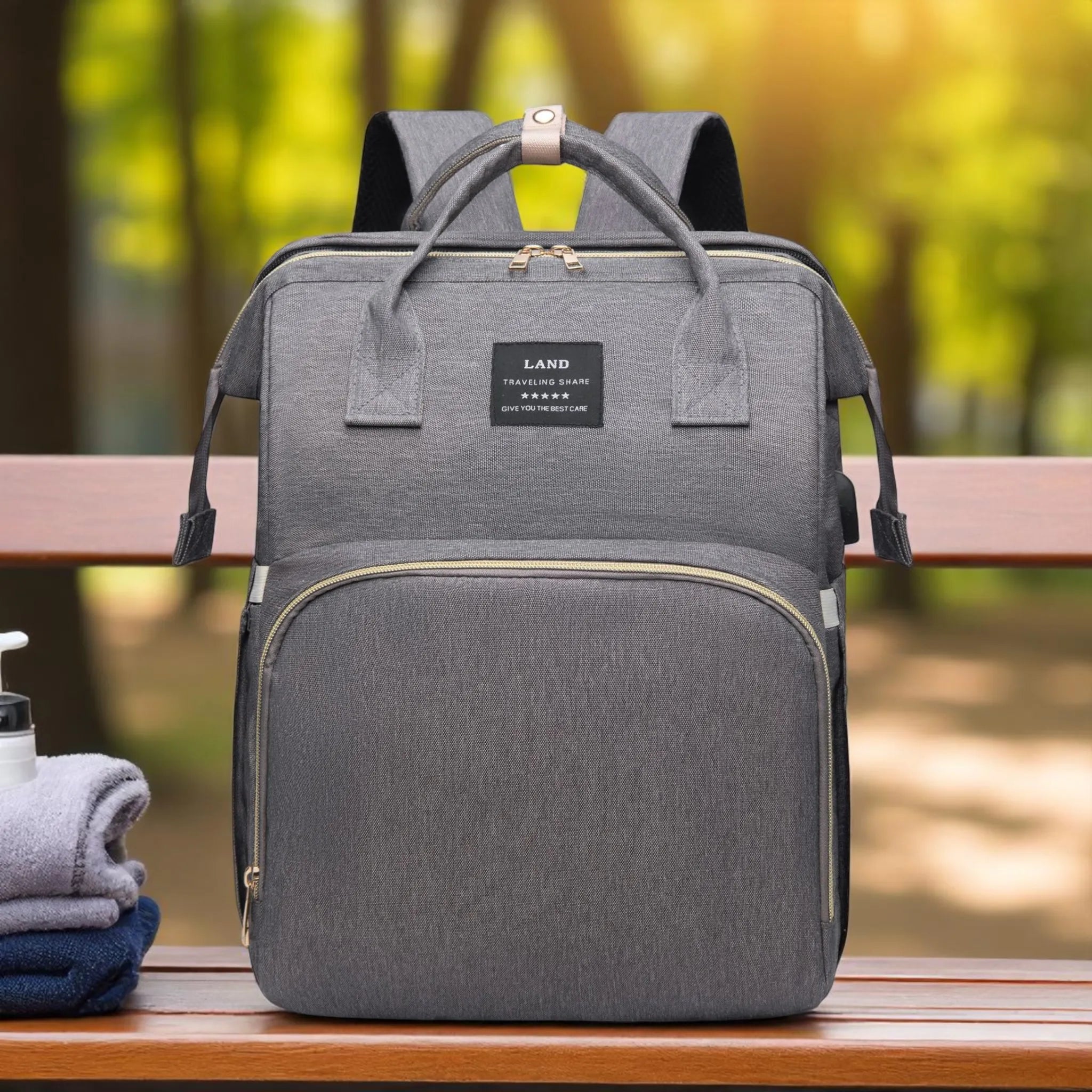 Gray backpack on a wooden bench with a blurred natural background
