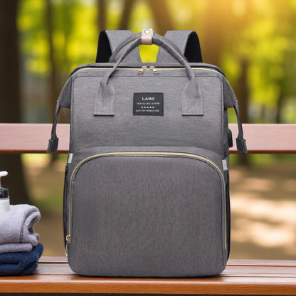 Gray backpack on a wooden bench with a blurred natural background