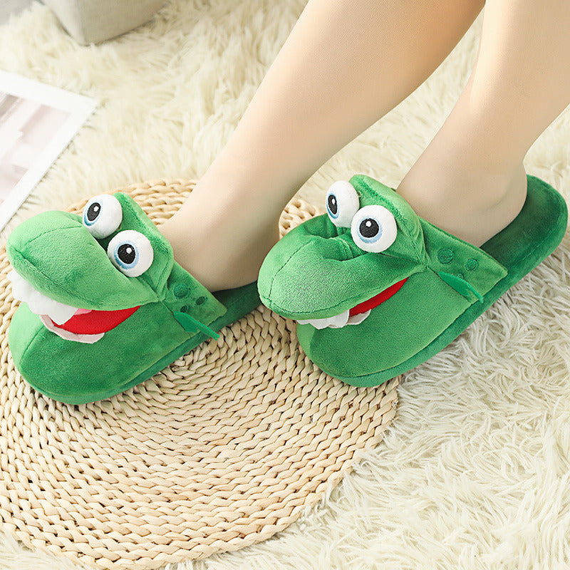 Green frog-themed slippers worn by a person on a textured floor.