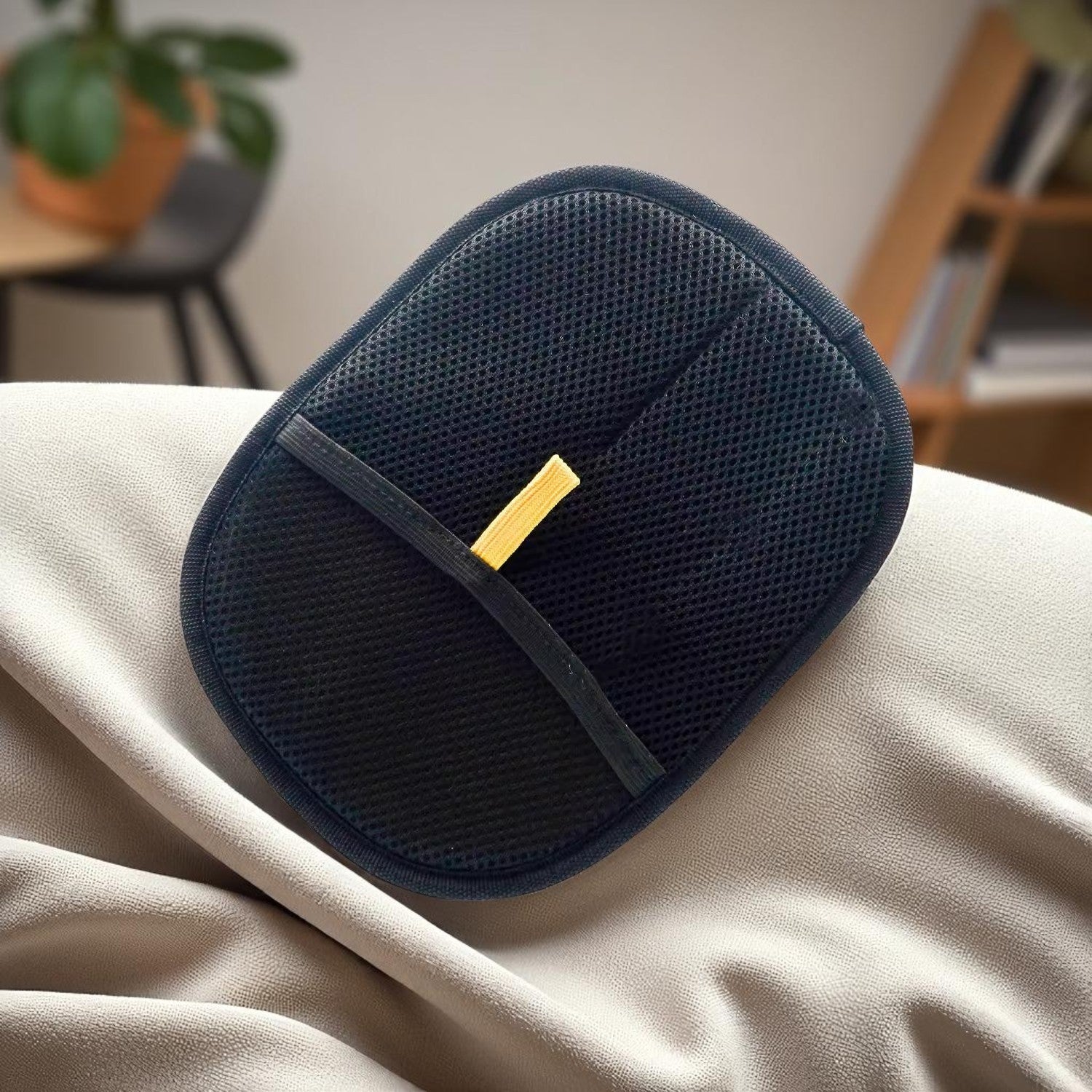 Blue mesh pouch with a gold tag on a beige surface, blurred indoor background